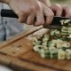 Chef chopping vegetables on wooden chopping board