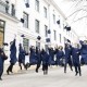 Graduates jumping and throwing their hats in the air
